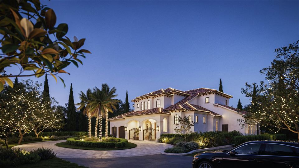 Two-story home at dusk with warm white Christmas lights on the roofline, palm trunks and trees